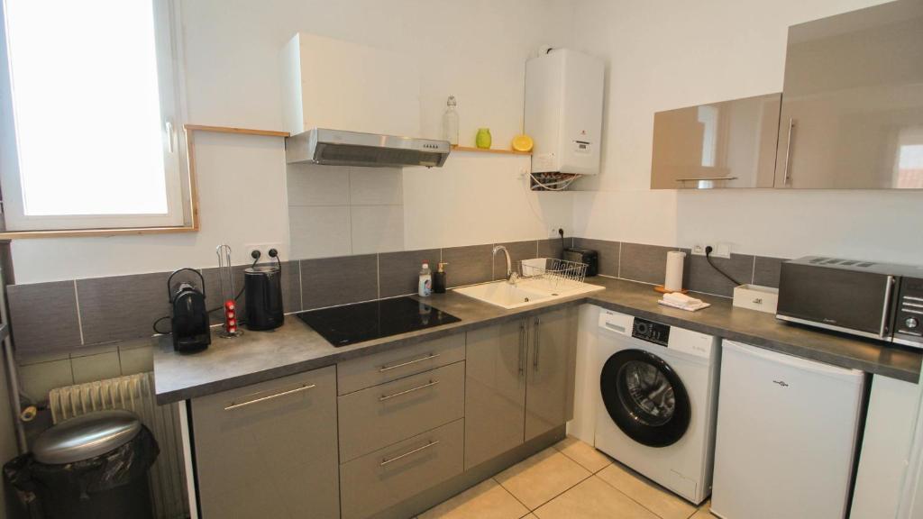 a kitchen with a sink and a washing machine at Residence Pasteur Angouleme in Angoulême