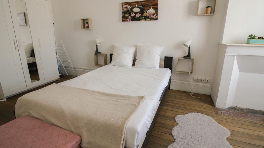 a bedroom with a white bed and a fireplace at Residence Pasteur Angouleme in Angoulême
