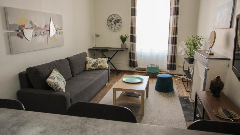 a living room with a couch and a table at Residence Pasteur Angouleme in Angoulême