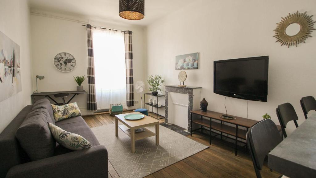 a living room with a couch and a flat screen tv at Residence Pasteur Angouleme in Angoulême