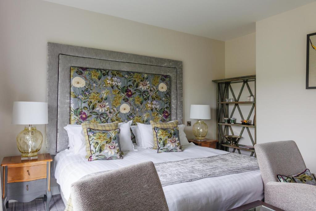 a bedroom with a large bed with a floral headboard at Peak Edge Hotel in Chesterfield