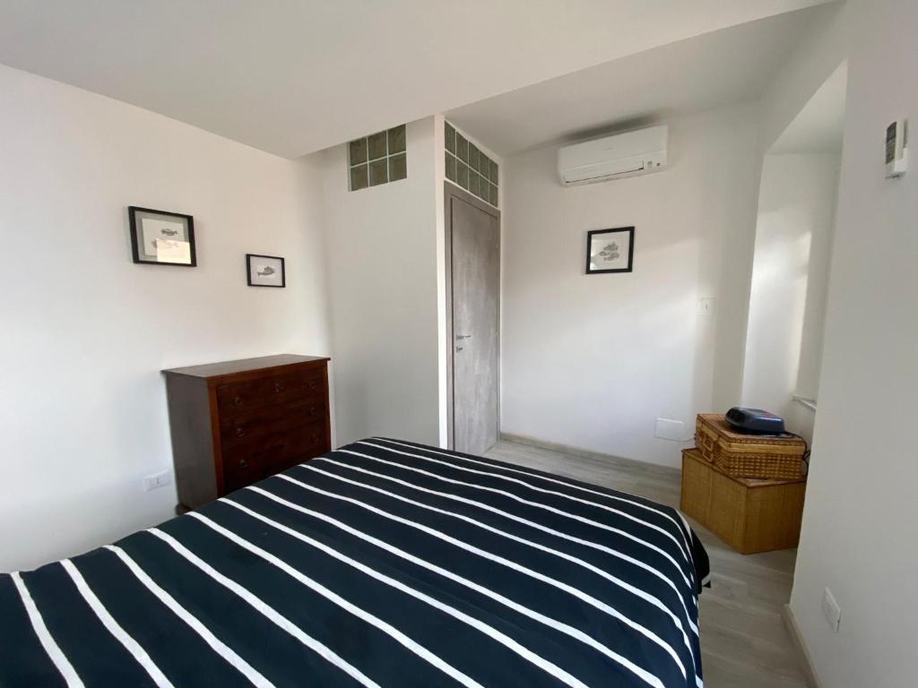 a bedroom with a bed with a blue and white stripes at Le finestre sul mare in Rio Marina