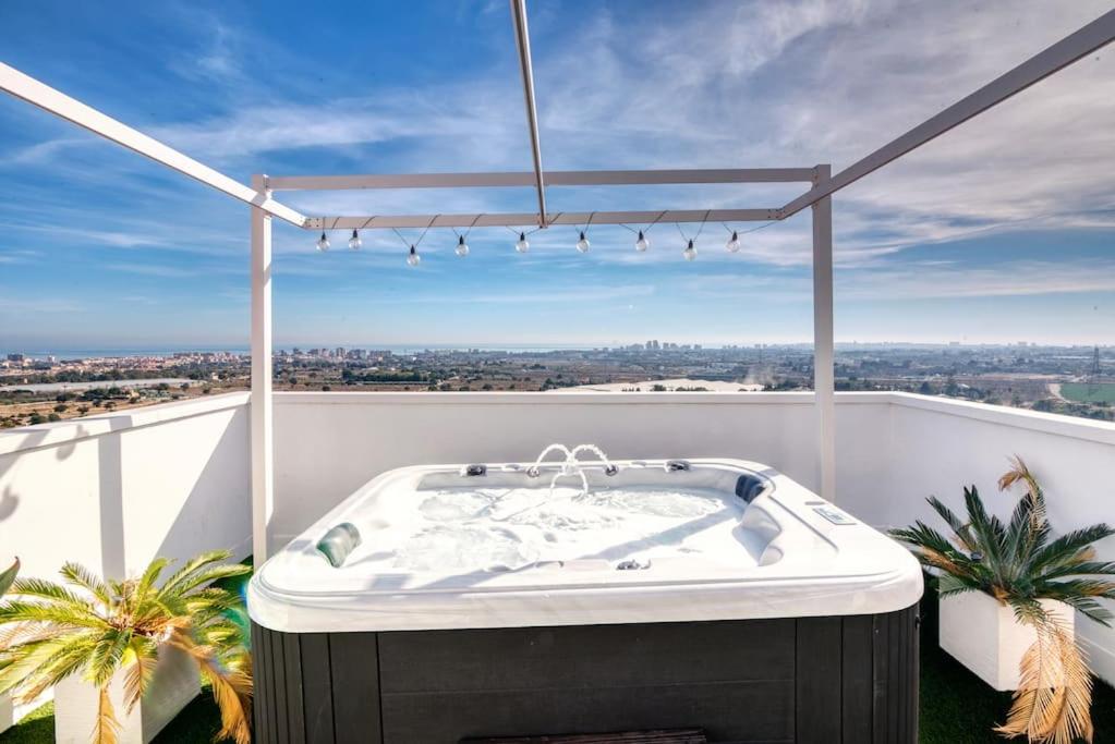 bañera de hidromasaje en el balcón de una casa en beautiful villa private pool & Jacuzzi with panoramic views, en Muchamiel