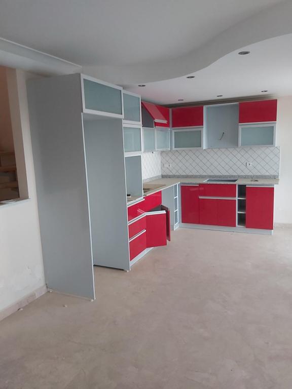 an empty kitchen with red and white cabinets at Antalya Ambiance Sitesinde in Antalya