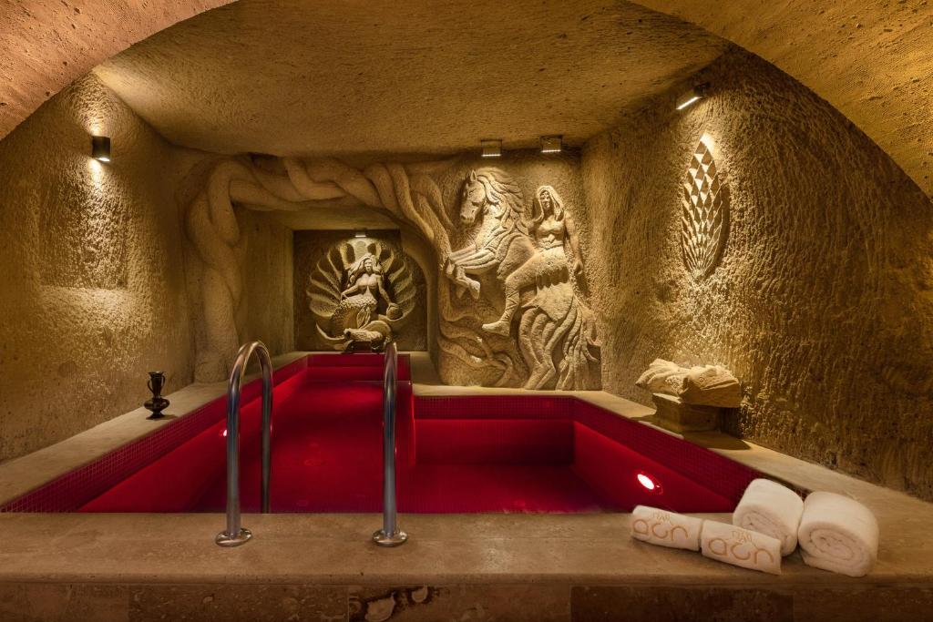 baño con bañera roja en una cueva en Cappadocia Acer Cave Hotel, en Ortahisar