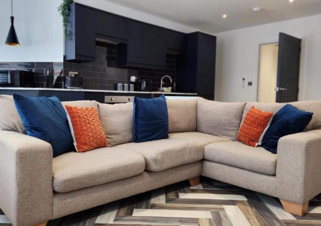 un divano con cuscini colorati, situato in un soggiorno di Kings Gate House DH ApartHotels a Peterborough