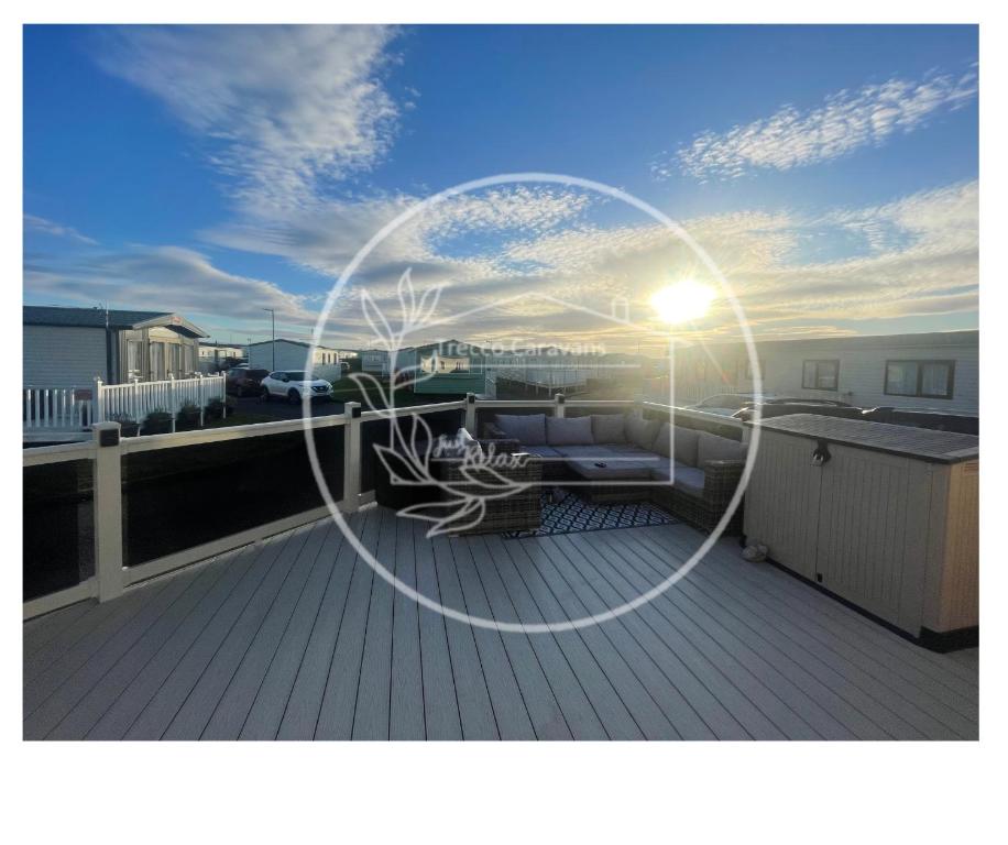 a picture of the sun setting on a deck at Trecco bay caravan hire 4 bedrooms sleeps 10 in Porthcawl