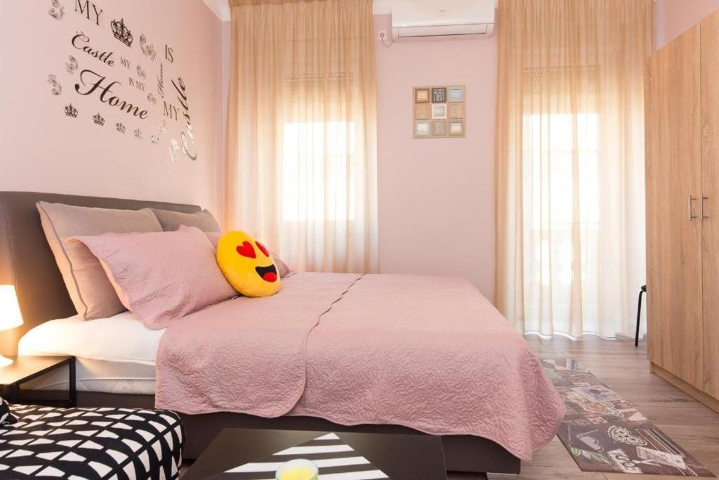 a bedroom with a bed with a pink blanket at Apartment Fiume in Rijeka