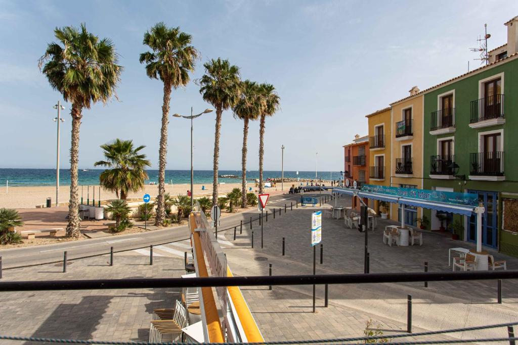 a view of a beach with palm trees and the ocean at Arsenal 31 by Seaward Suites in Villajoyosa