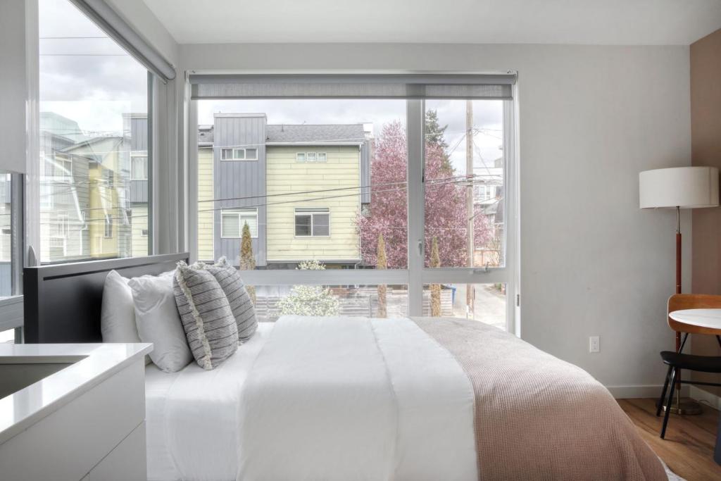 Habitación blanca con ventana grande y cama en Blueground Capitol Hill patio walkable area SEA-722 en Seattle