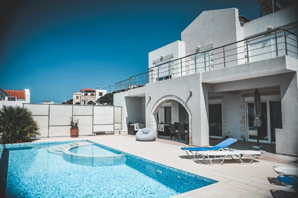 a villa with a swimming pool and a house at Villa Icare in Kókkinon Khoríon