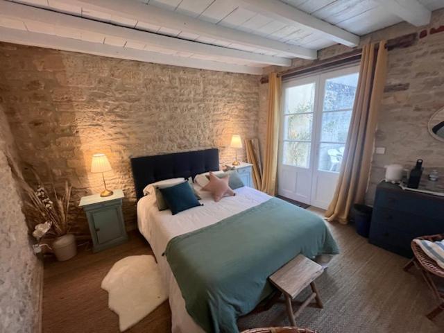 a bedroom with a large bed and a large window at La Bonne Brise in Grandcamp-Maisy