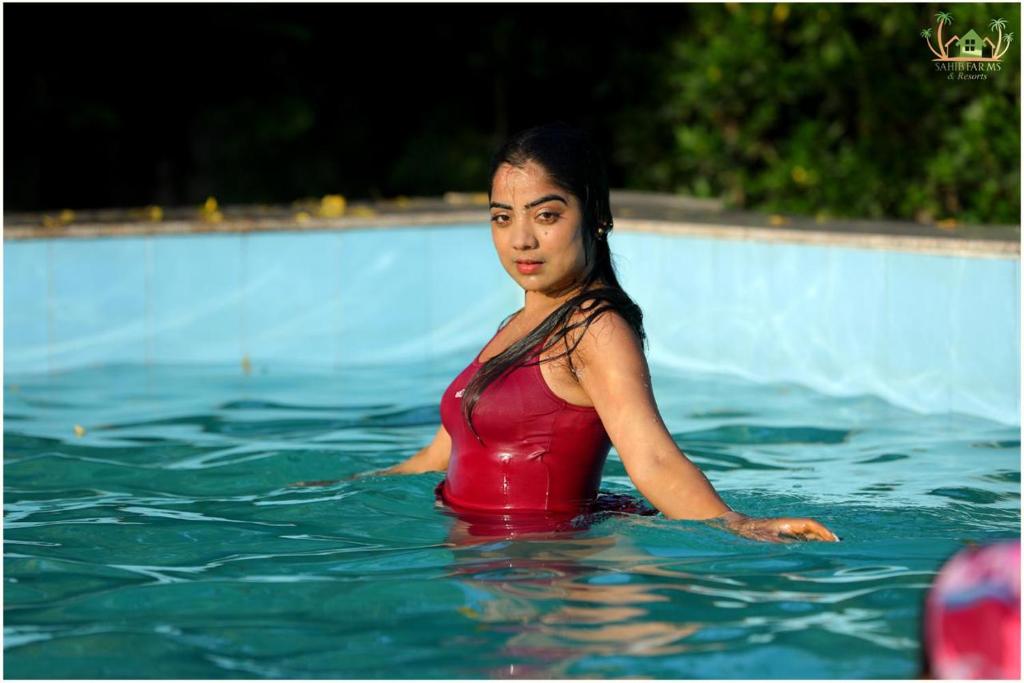 a woman in the water in a swimming pool at Sahib Farms and Resorts in Delhi
