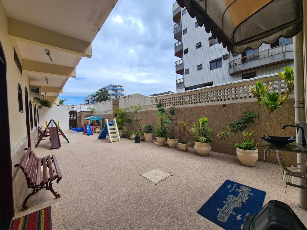a patio with a playground and plants in a building at Pousada Aquários in Cabo Frio