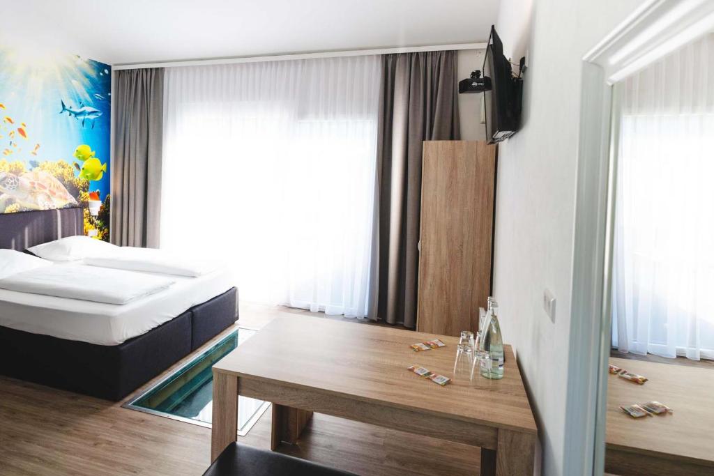 a bedroom with a bed and a table in it at Pension am Park in Rust