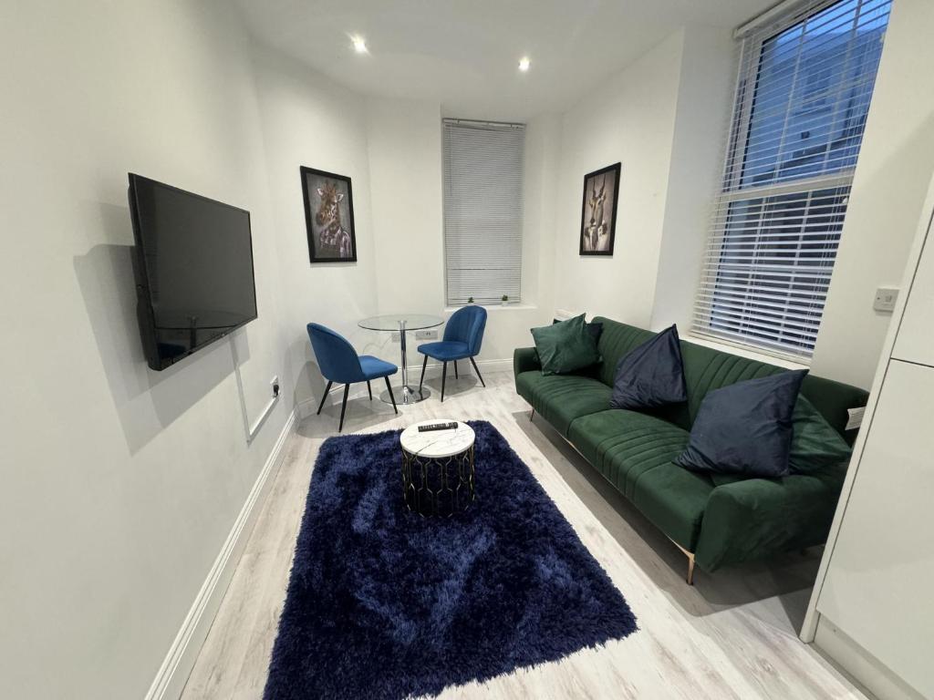 a living room with a green couch and a table at Beautiful 1-Bed Apartment in Walton on the Naze in Walton-on-the-Naze