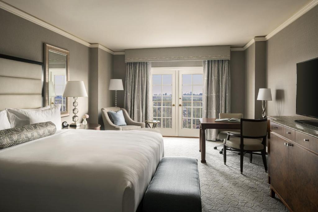 クレイトンにあるThe Ritz-Carlton, St. Louisのベッド、デスク、コンピュータが備わるホテルルームです。