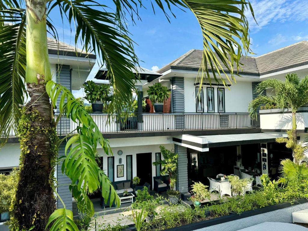 una vista exterior de una casa con palmeras en Villa Rumah Putih Abu Abu, en Senggigi 