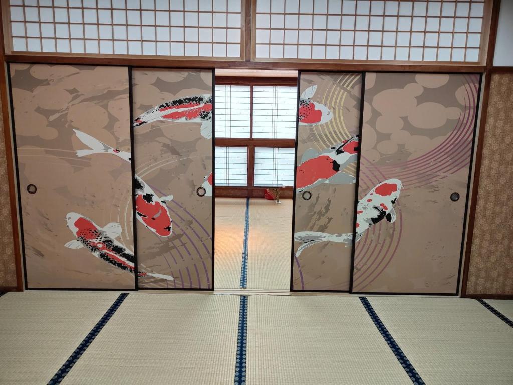 a room with doors with koi paintings on them at Morita-ya Japanese style inn KingyoーVacation STAY 62437 in Tamana