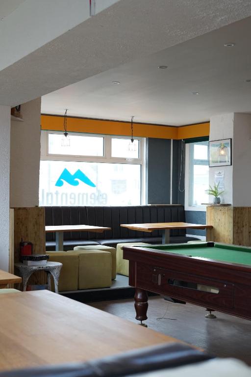 a room with a pool table and couches at Elemental Surf Lodge in Newquay