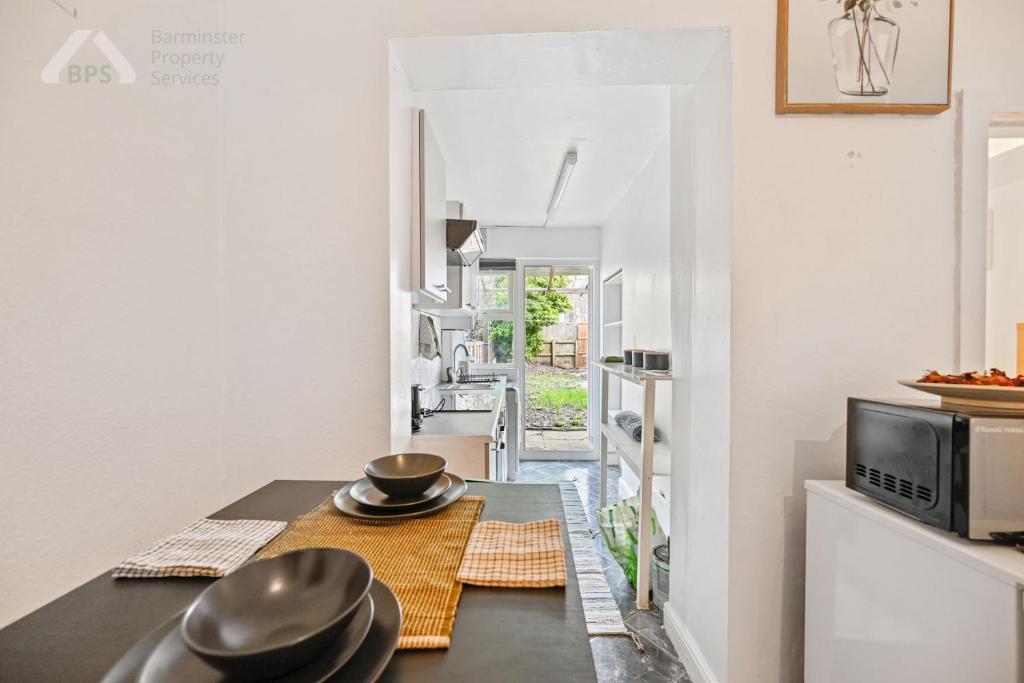 a kitchen with a table with hats on it at Cosy Tottenham Apartment Sleeps 4 in London
