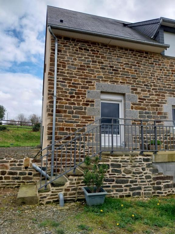 a brick house with a stone staircase and a window at Gite Du Palefrenier in Brécey