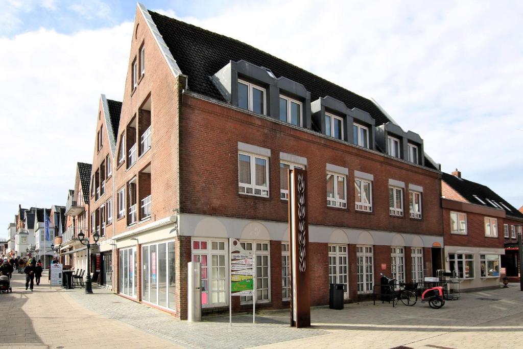 - un grand bâtiment en briques dans une rue de la ville dans l'établissement Sandwall 2_ Whg_ 6, à Wyk auf Föhr