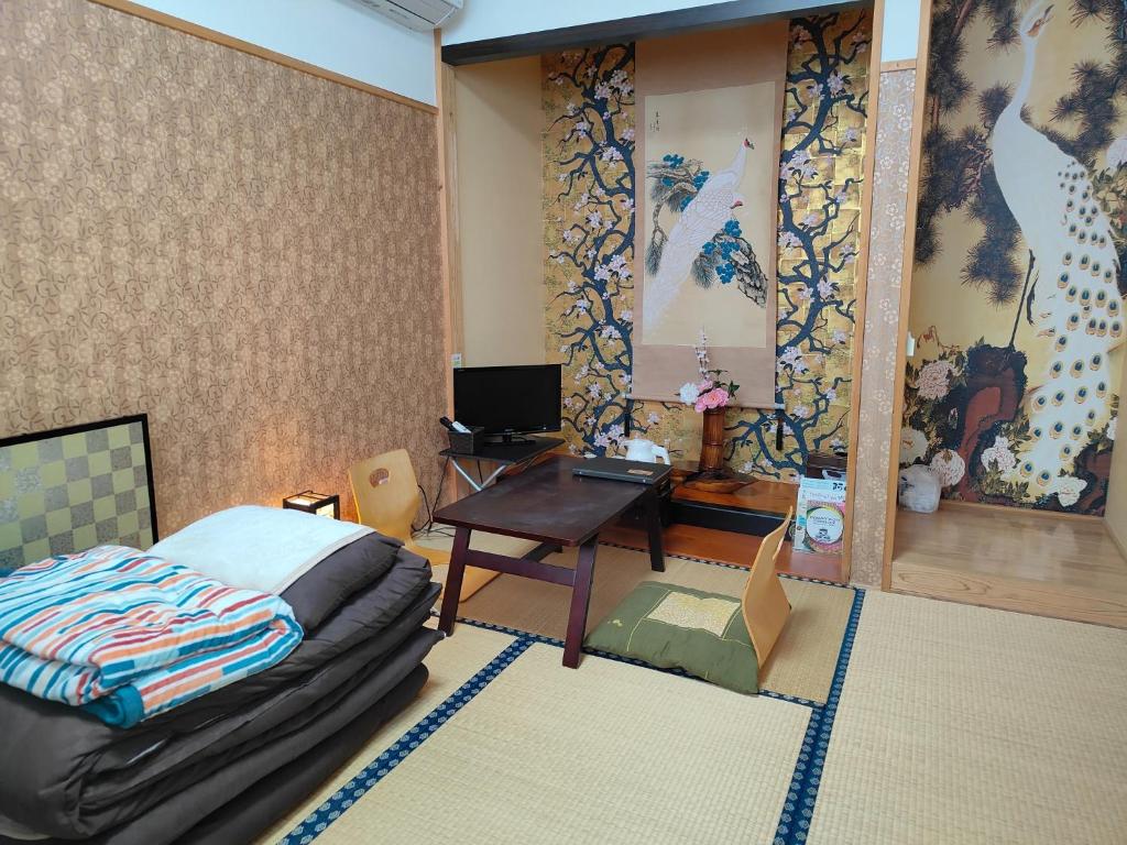 1 dormitorio con cama, escritorio y mesa en Morita-ya Japanese style inn KujakuーVacation STAY 62460, en Tamana