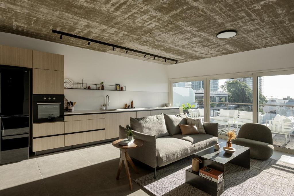 a living room with a couch and a kitchen at Mr. Rothschild by TLV2GO in Tel Aviv
