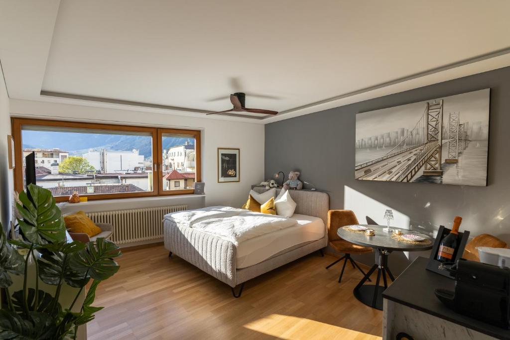 een slaapkamer met een bed en een groot raam bij Ausblick Kleinjuwel mit Panoramablick + Garage in Merano