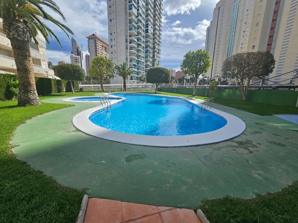 una piscina in un parco con edifici alti di Apartamento Benimar Beach a Benidorm