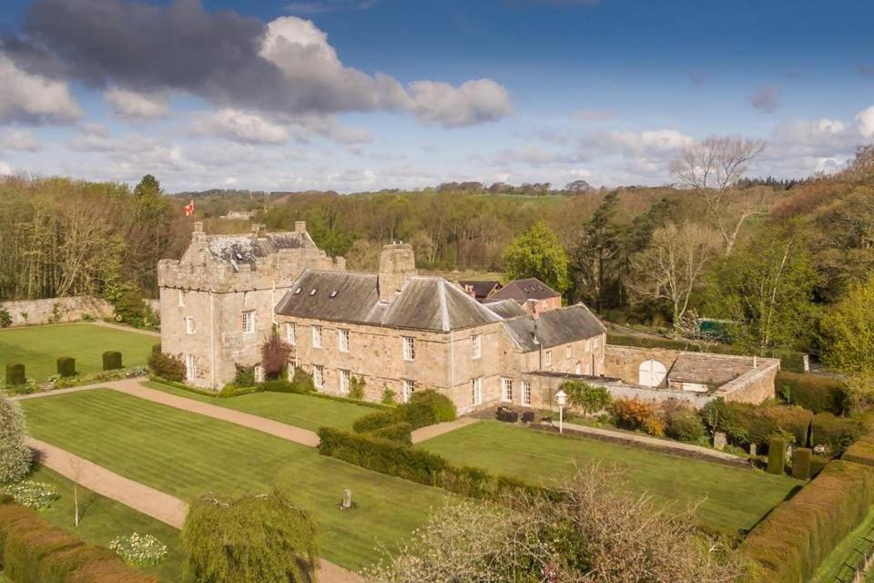 an aerial view of an old castle with a green lawn at Shortflatt Tower in Longwitton