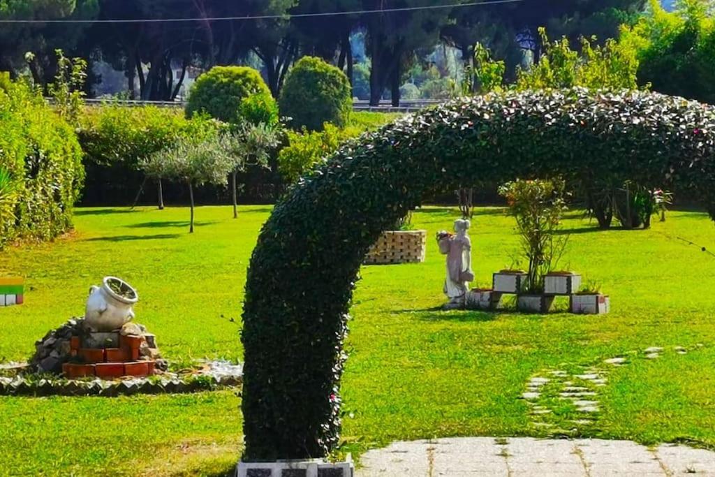 duży zielony łuk w parku z posągiem w obiekcie -Villa Gardenia- [Private Garden & Free Parking] w mieście Sarzana