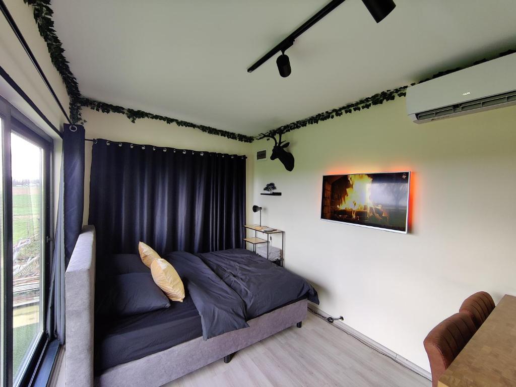 a bedroom with a bed in a room with a window at Tiny House Betuwe in Tricht