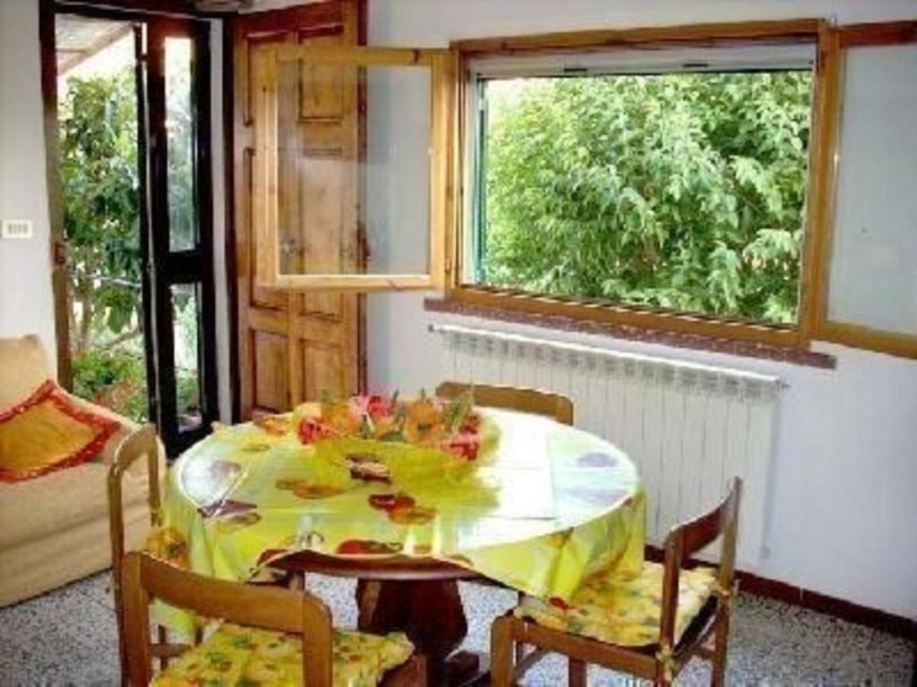 een eetkamer met een tafel met een geel tafelkleed bij Ferienwohnung für 5 Personen ca 70 qm in Paganico, Toskana Maremma in Paganico