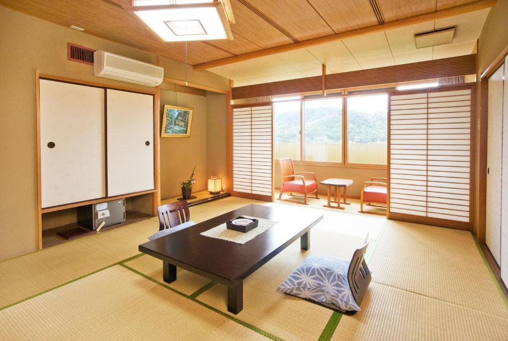 ein Wohnzimmer mit einem Tisch und Stühlen in der Unterkunft Yumenoi in Himeji