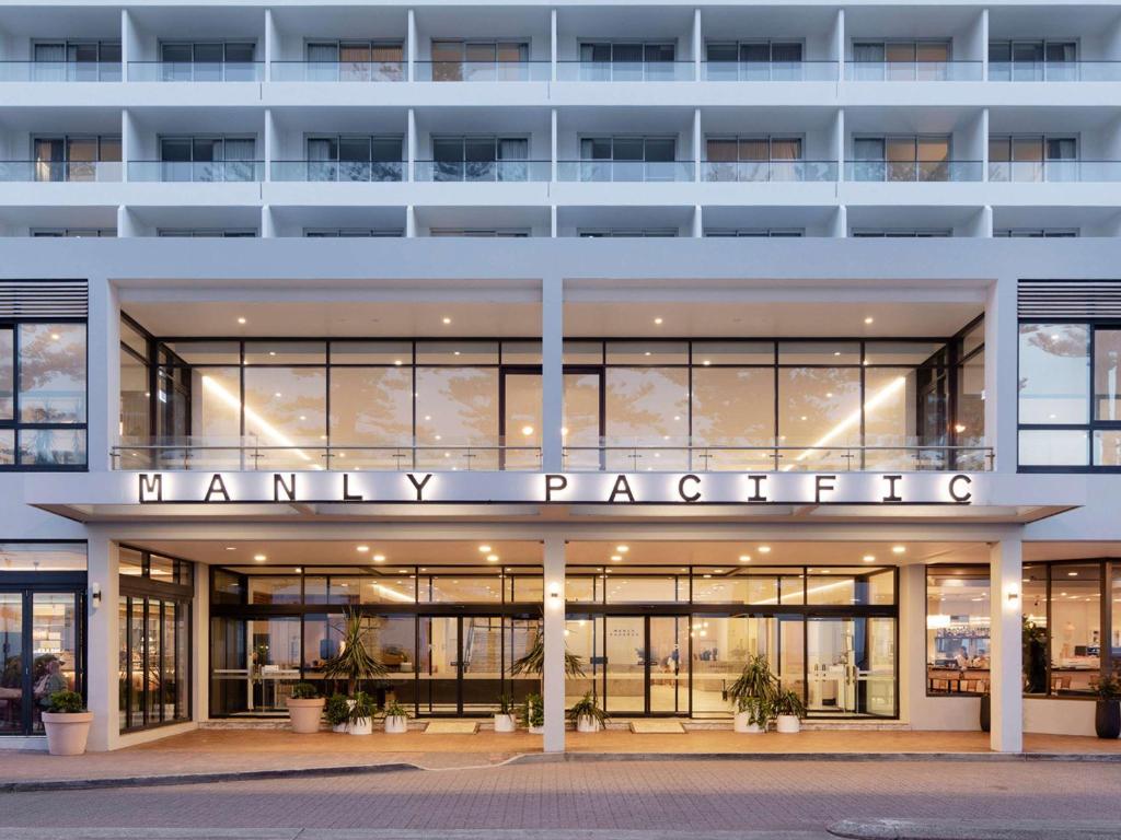 un grand bâtiment blanc avec un panneau de pharmacie. dans l'établissement Manly Pacific Sydney MGallery Collection, à Sydney