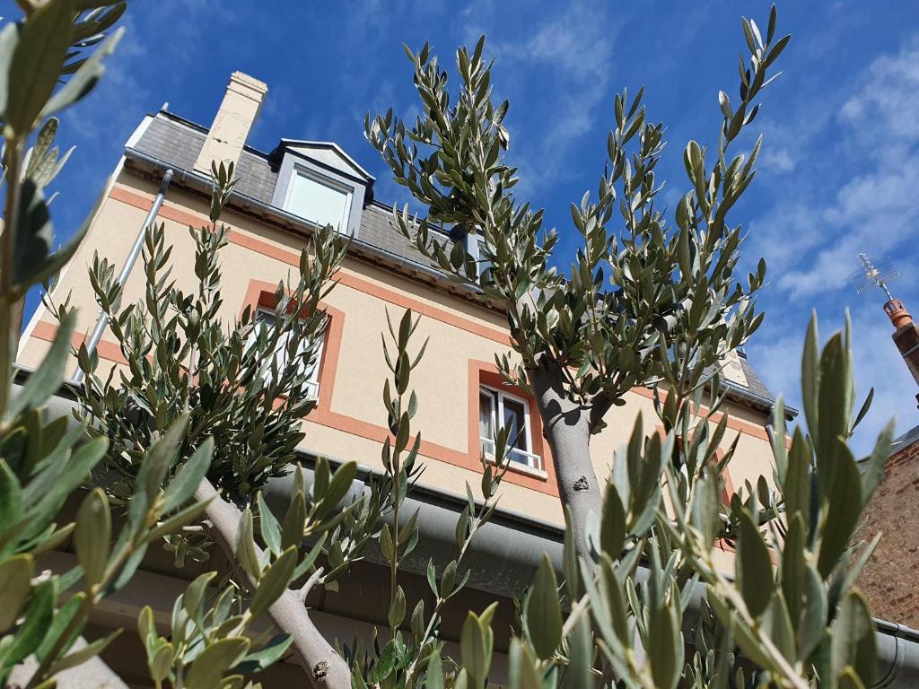 un bâtiment avec un arbre en face dans l'établissement Villa Les Bains, à Houlgate