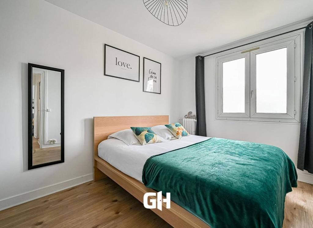 une chambre avec un grand lit et un miroir dans l'établissement Le Coquet - 4 pers - Paris / La Défense - Parking, à Courbevoie