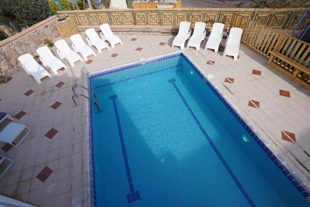 a swimming pool with chairs and a swimming pool at YalaRent Afarsemon Apartments with pool - For Families & Couples in Eilat