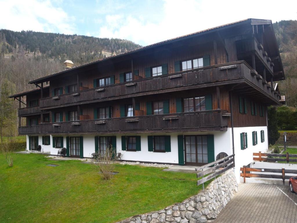 um grande edifício de madeira com um banco em frente em Beautiful lodging in the Alps near Bayrischzell em Bayrischzell