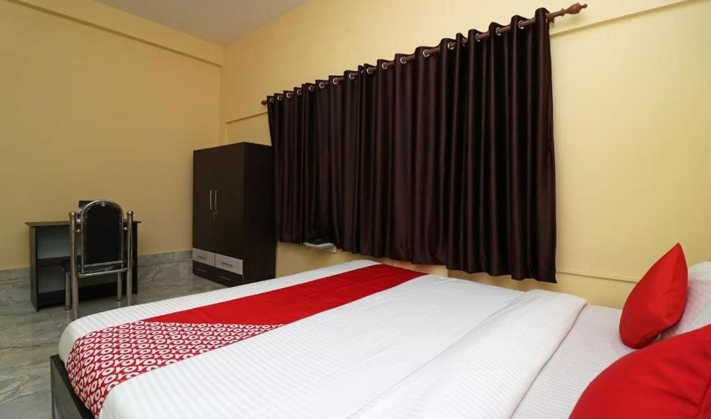 - une chambre avec un grand lit et des oreillers rouges dans l'établissement MOSS GUEST HOUSE, à kolkata