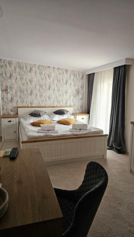 a bedroom with a large bed and a table at Pensiune Heavens in Brăila