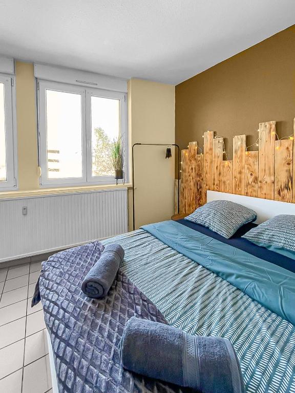 une chambre avec un grand lit et deux fenêtres dans l'établissement Échappée Belle à Épinal, à Épinal