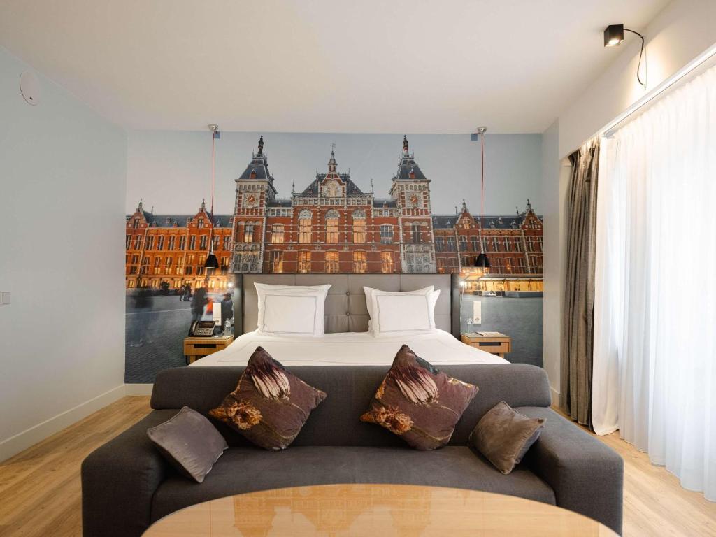 - une chambre avec un lit et un grand bâtiment dans l'établissement Swissôtel Amsterdam, à Amsterdam
