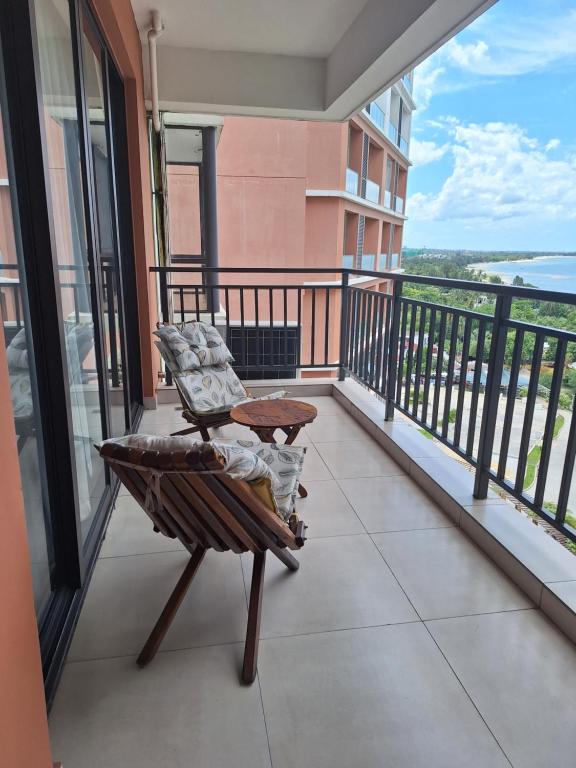 a balcony with a chair and a table at Sabra Palmvillage mikocheni in Dar es Salaam
