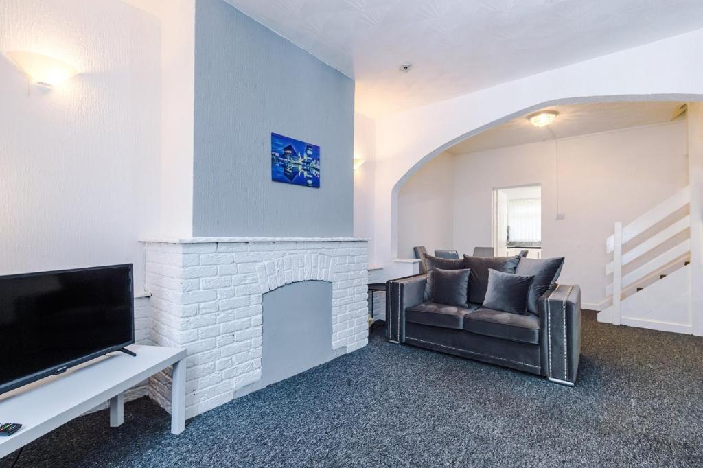 a living room with a couch and a fireplace at 2 Bedroom | Central location in Saint Helens