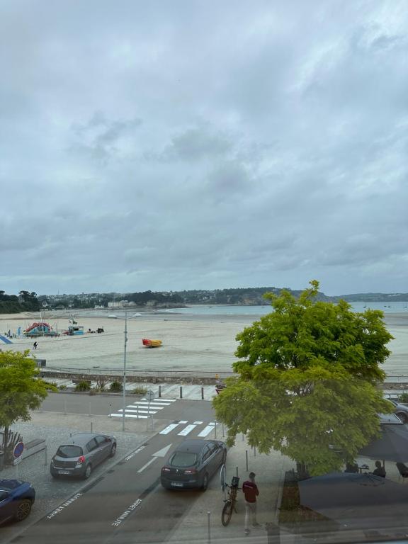 uma vista para um parque de estacionamento com carros e uma praia em Presqu’île Crozon-Morgat em Crozon