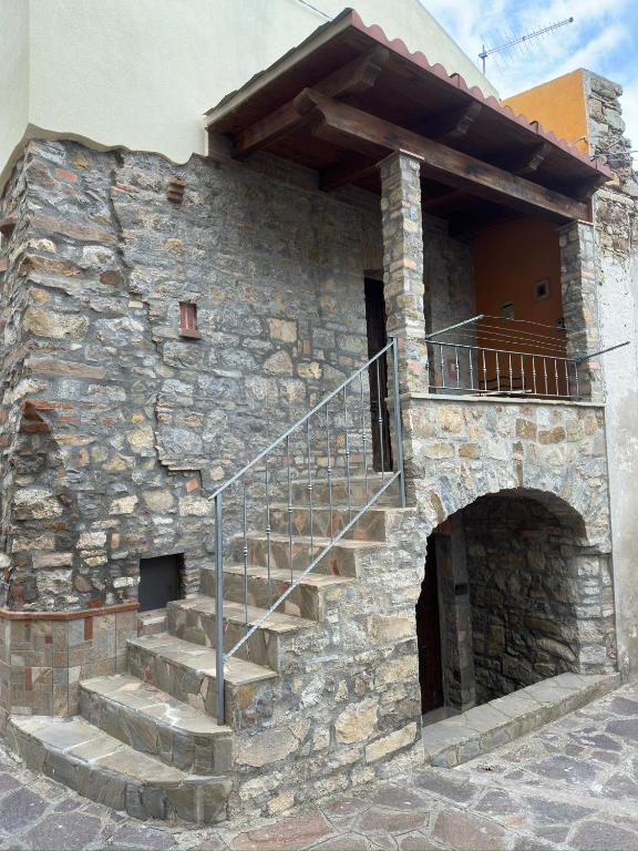 un edificio de piedra con escaleras en su lateral en Appartamento La Petrosa, en Nova Siri