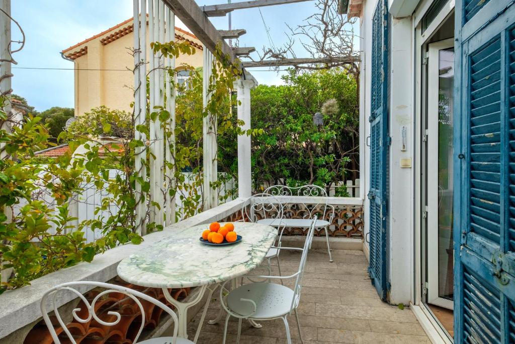 - une table et des chaises sur un balcon avec des oranges dans l'établissement Maison avec studio Cros de Cagnes, à Cagnes-sur-Mer